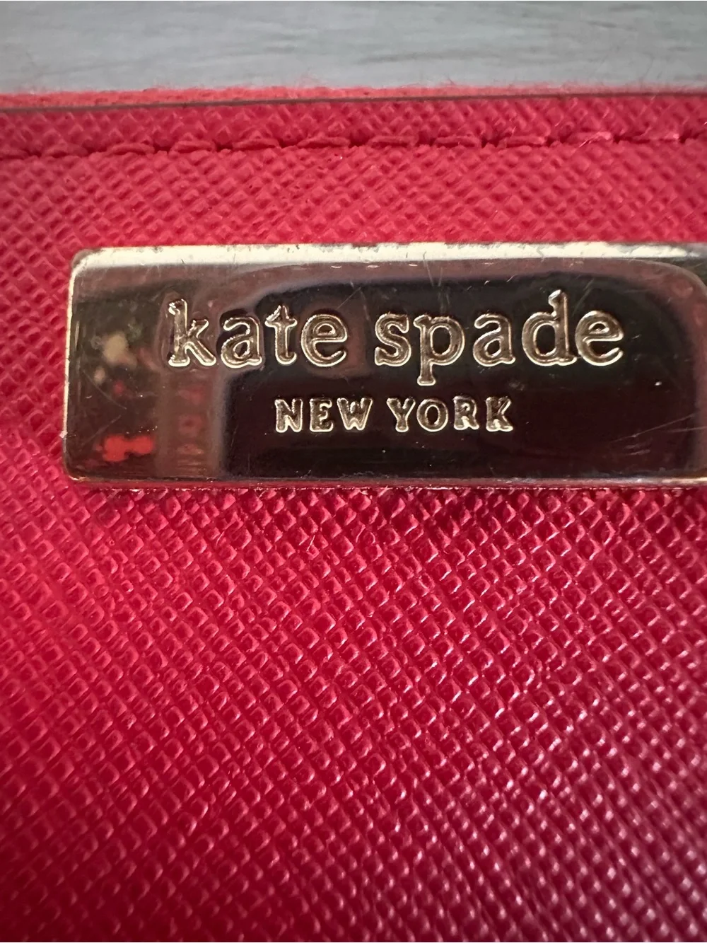 kate spade saffiano zip-around wallet in vibrant red with gold plaque